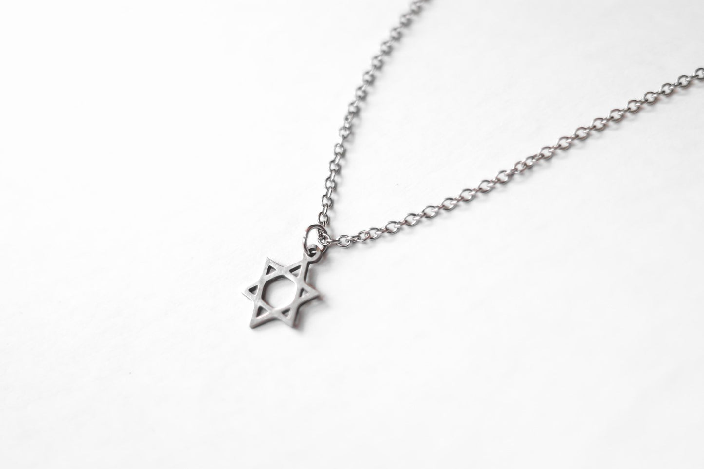 Silver necklace with a star pendant on a white background