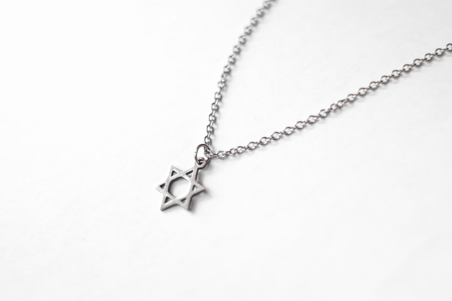 Silver necklace with a star pendant on a white background